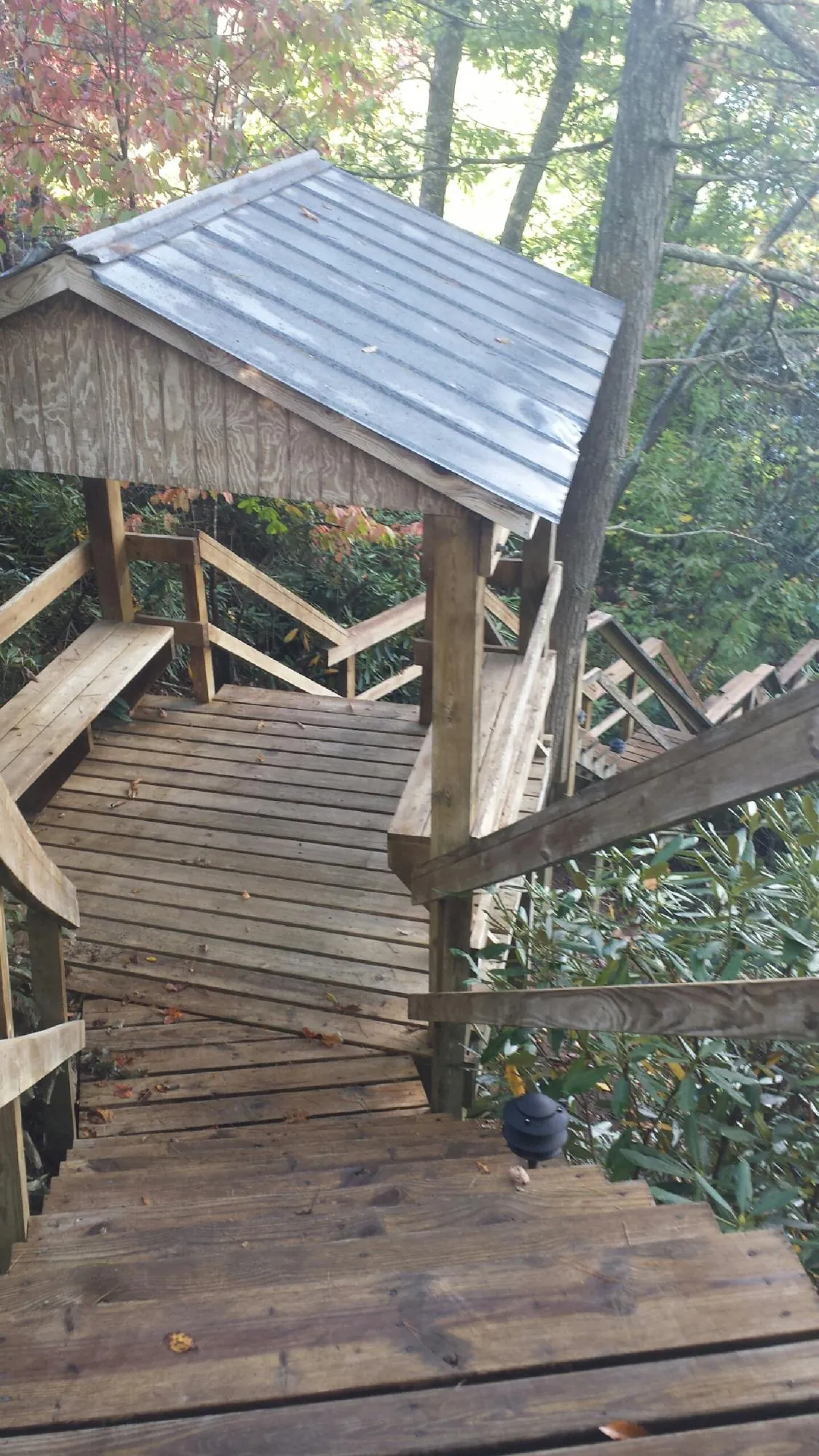 Metal roofed shelter over wooden steps on a wooded walkway — Skylight Repair & Installation work by our crew in Indian Head