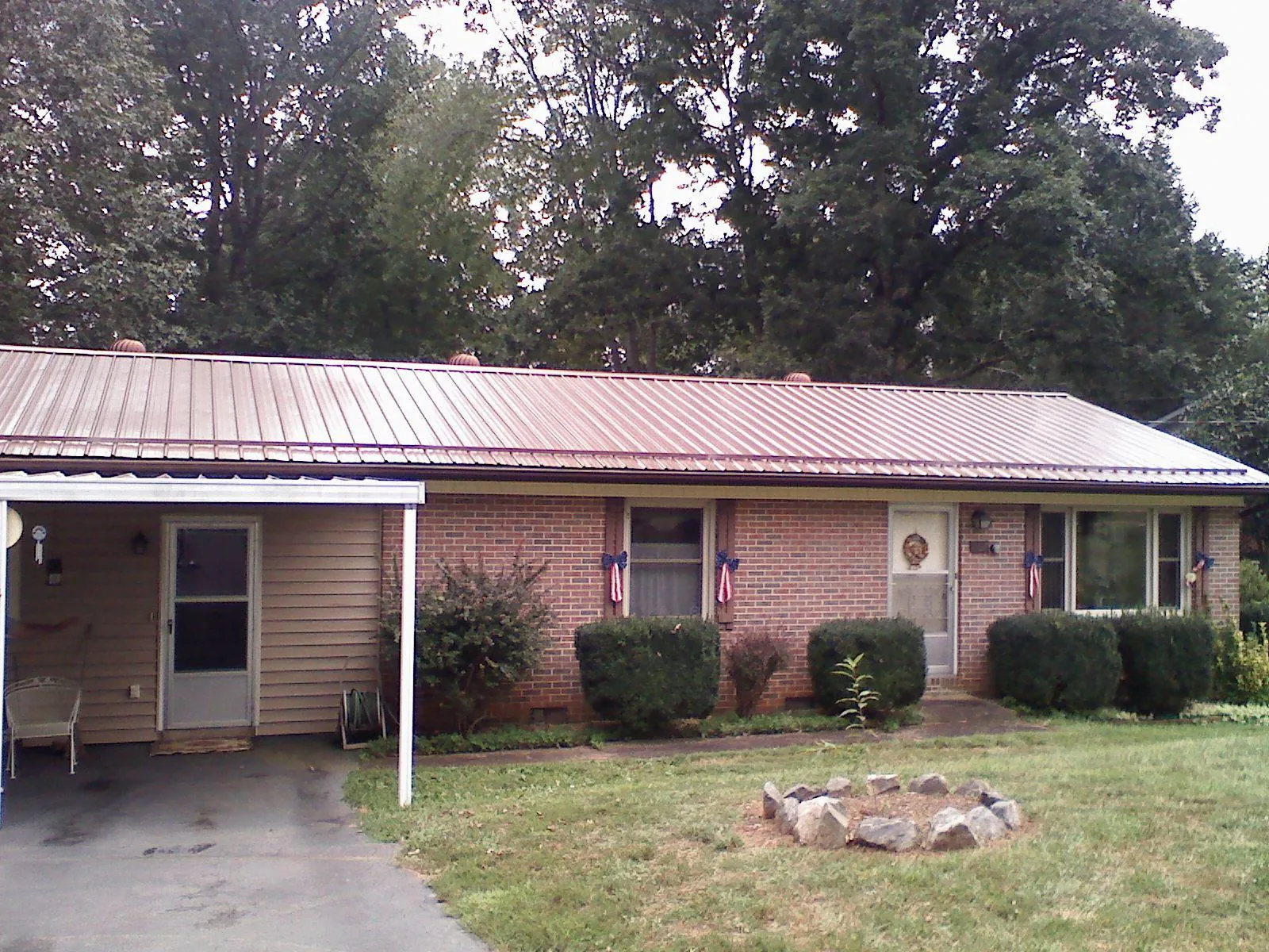 Bronze metal roof and carport on a brick ranch home — Roof Repair work by our crew in Indian Head